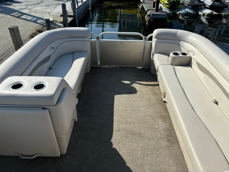 Slide: The Image of 2014 Bennington 24 SSLX pontoon boat interior with beige seating and cup holders. - 13
