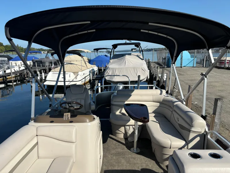 Slide: The Image of 2014 Bennington 24 SSLX pontoon boat with canopy, docked at marina. - 2