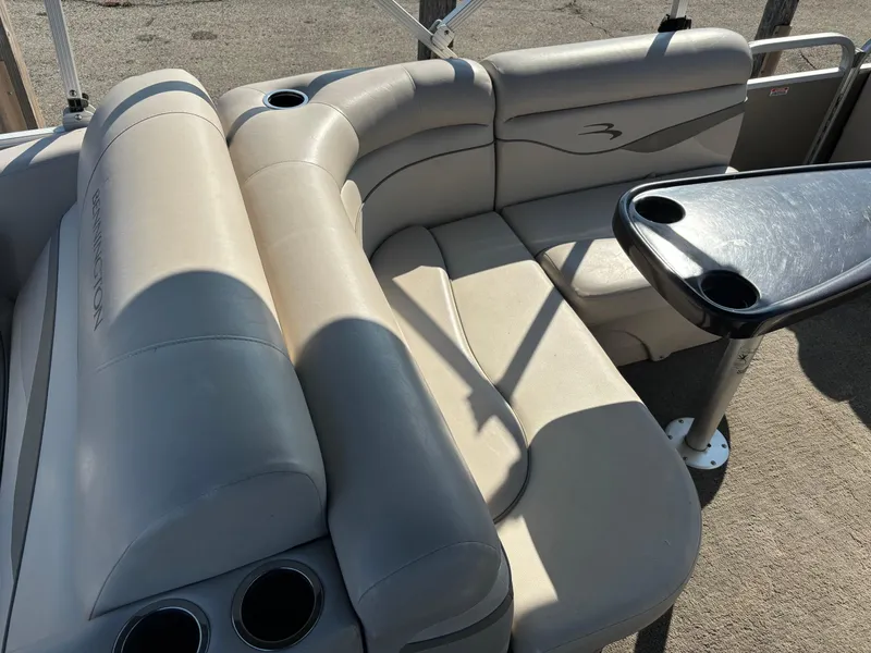 Slide: The Image of 2014 Bennington 24 SSLX boat interior with beige seating and cup holders. - 4