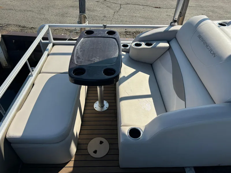 Slide: The Image of 2014 Bennington 24 SSLX pontoon boat seating area with table and cup holders. - 5