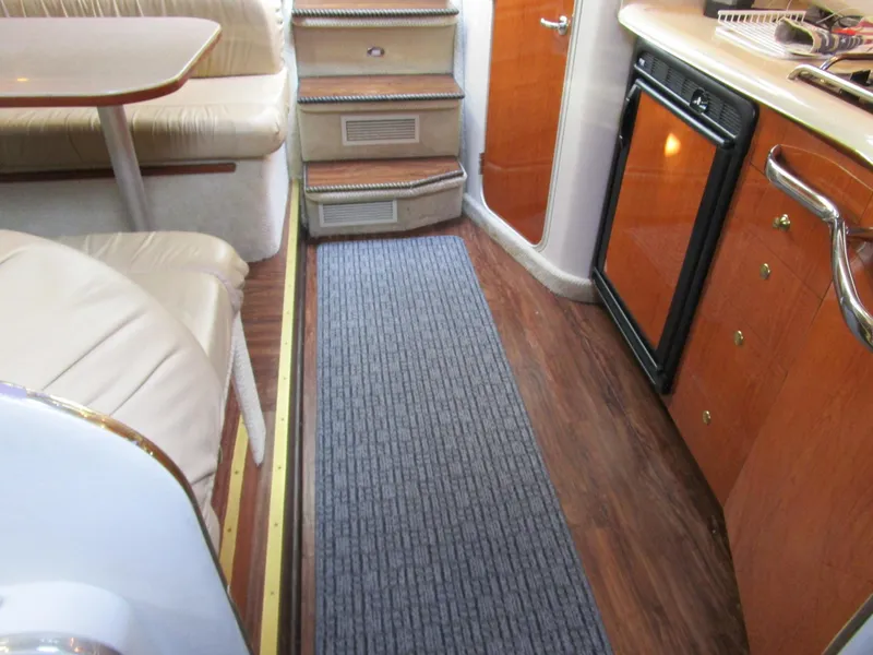 Slide: The Image of Interior of 2001 Sea Ray 340 Amberjack with wood flooring and compact kitchen area. - 20
