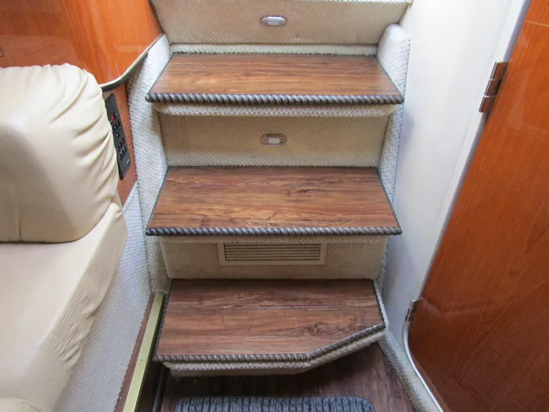 Slide: The Image of Wooden steps inside 2001 Sea Ray 340 Amberjack boat, featuring elegant design and cozy interior. - 21
