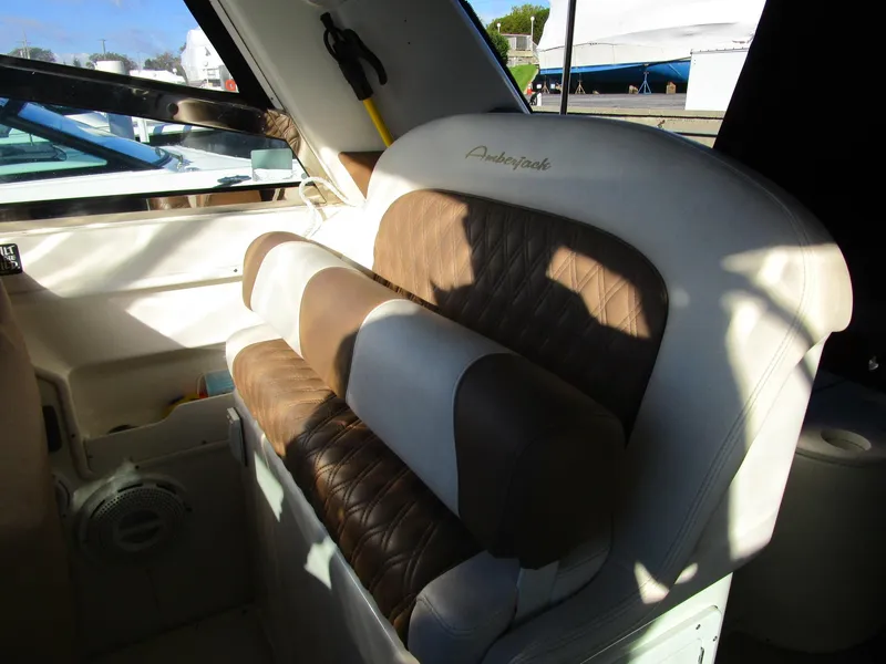 Slide: The Image of 2001 Sea Ray 340 Amberjack interior with cushioned seating and window view. - 7