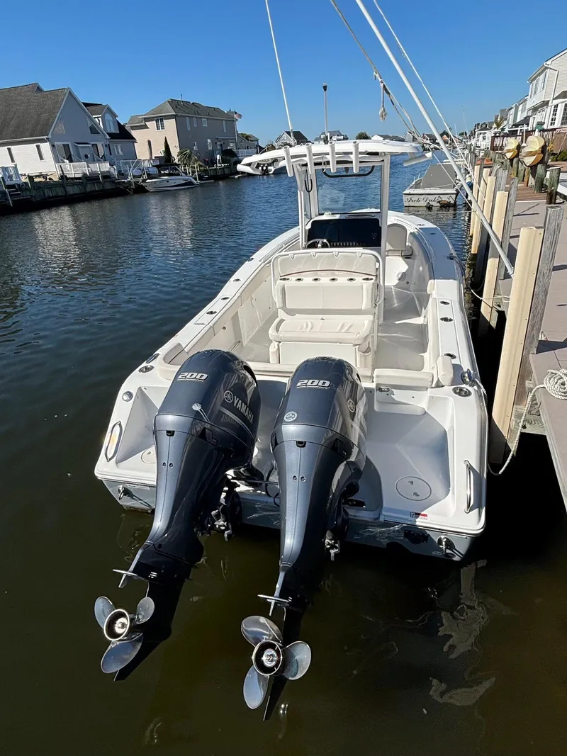 Slide: The Image of 2020 Sea Hunt Ultra 275 SE boat with dual engines docked in a marina. - 17