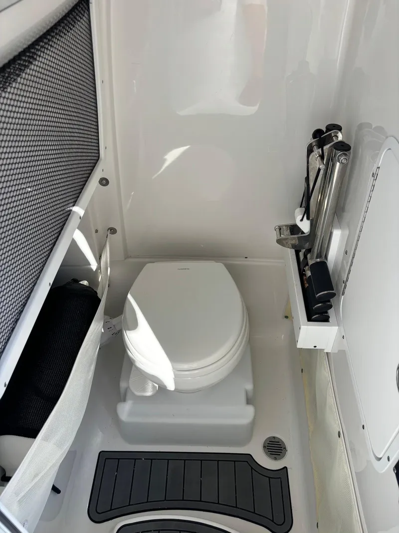 Slide: The Image of 2020 Sea Hunt Ultra 275 SE boat bathroom with compact toilet and storage. - 24