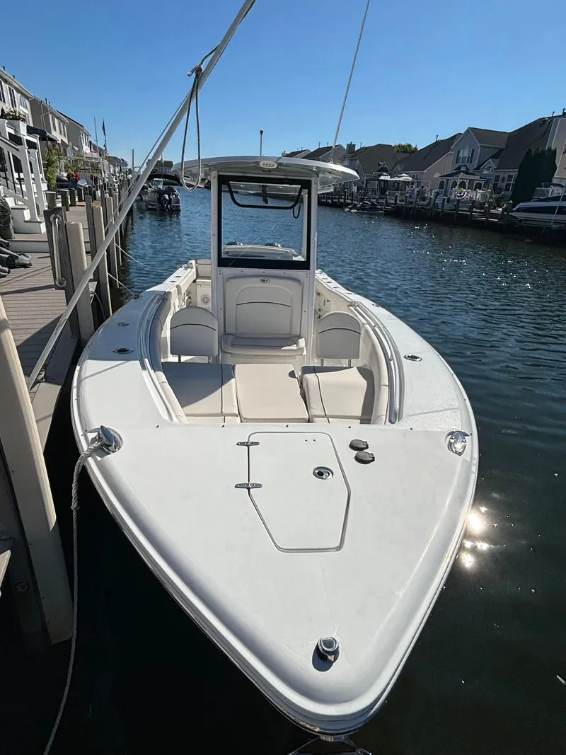 Slide: The Image of 2020 Sea Hunt Ultra 275 SE boat docked in a marina under clear blue skies. - 5