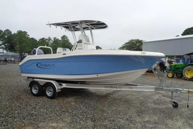 Slide: The Image of 2025 Robalo R200 Center Console boat on trailer, blue and white design. - 15