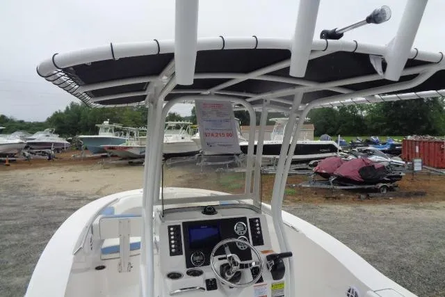 Slide: The Image of 2025 Robalo R200 Center Console boat with T-top and navigation controls, parked outdoors. - 29