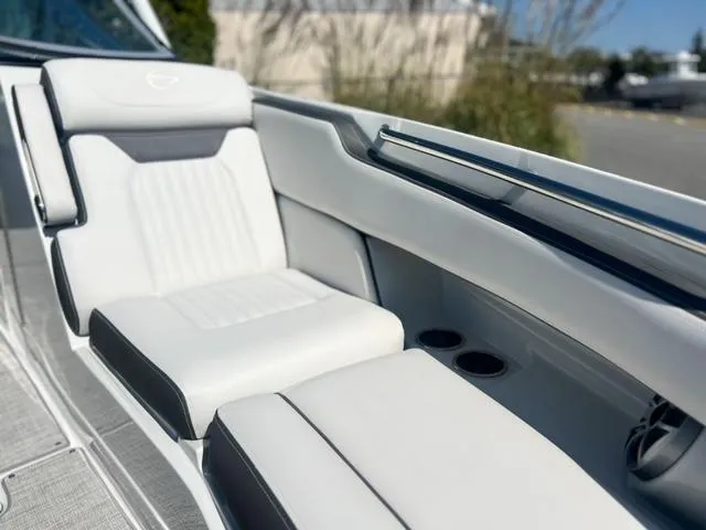 Slide: The Image of 2025 Crownline 290 XSS boat interior with white cushioned seating and cup holders. - 17