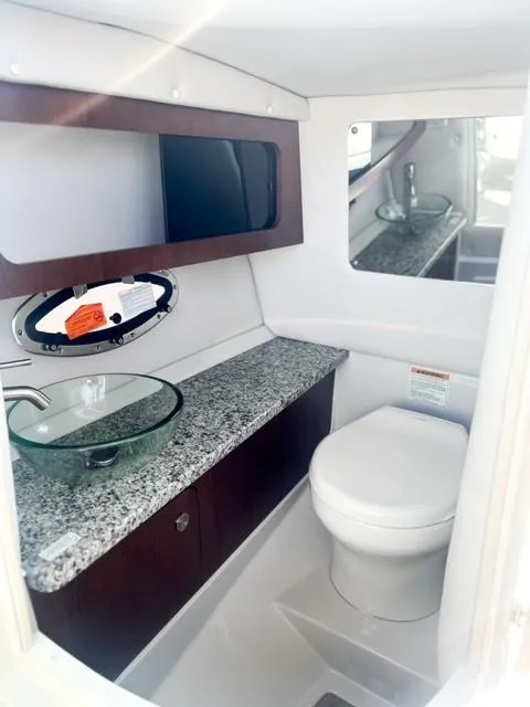 Slide: The Image of 2025 Crownline 290 XSS boat bathroom with granite countertop and modern fixtures. - 19