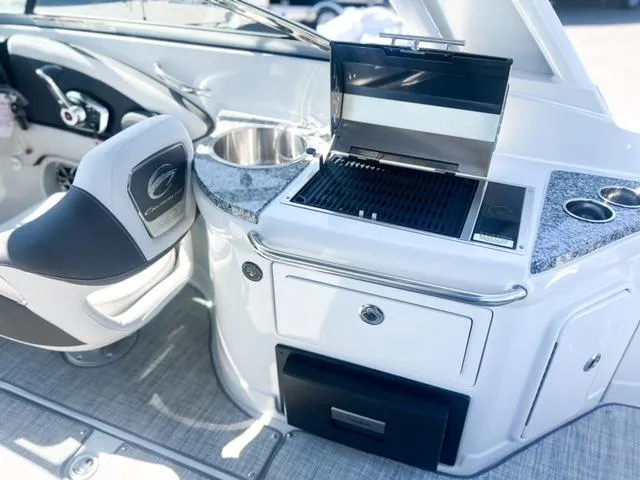 Slide: The Image of 2025 Crownline 290 XSS boat interior with grill and sink, featuring modern design elements. - 22
