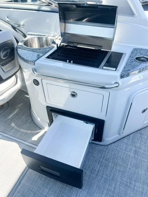 Slide: The Image of 2025 Crownline 290 XSS boat with built-in grill and storage drawer. - 24