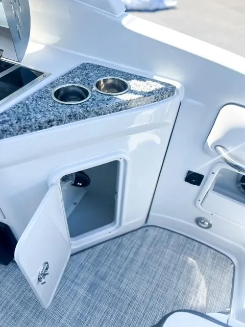 Slide: The Image of 2025 Crownline 290 XSS boat interior with granite countertop and storage compartment. - 25