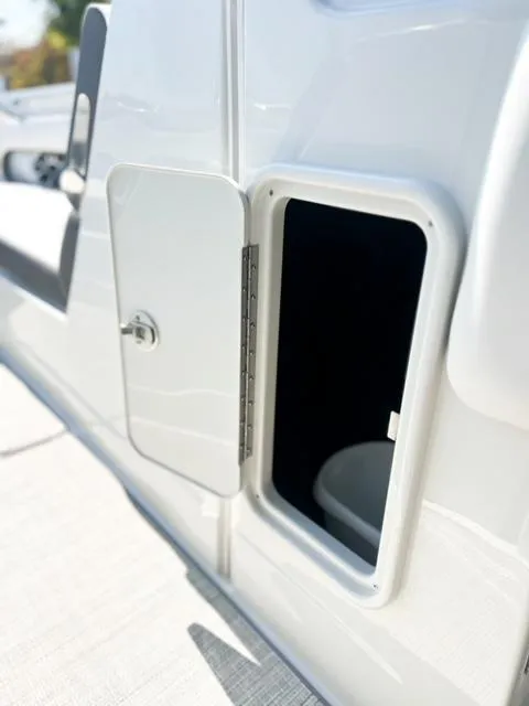 Slide: The Image of 2025 Crownline 290 XSS boat storage compartment with open door. - 27
