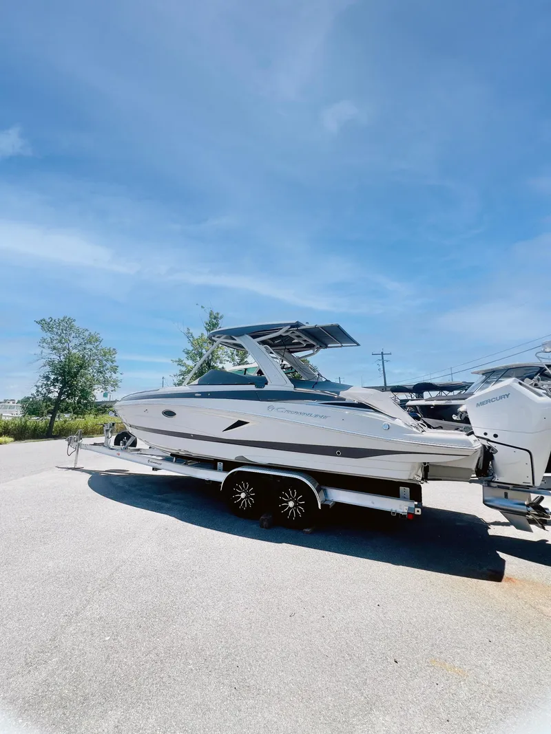 Slide: The Image of 2025 Crownline 290 XSS boat on trailer under clear blue sky. - 3