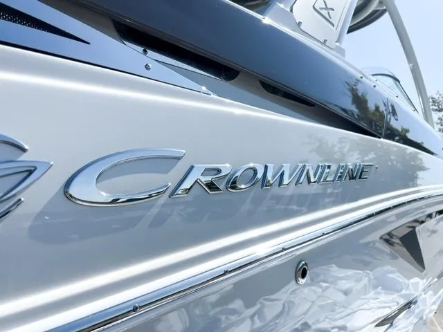 Slide: The Image of 2025 Crownline 290 XSS boat, sleek silver exterior with chrome logo detailing. - 4