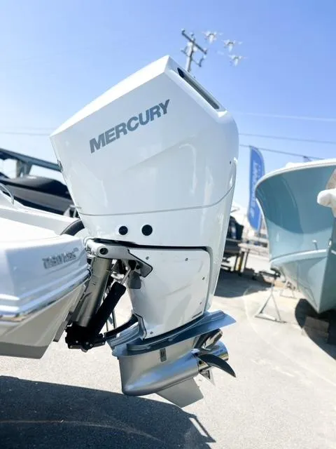 Slide: The Image of 2025 Crownline 290 XSS with Mercury outboard motor, displayed outdoors under clear blue sky. - 6