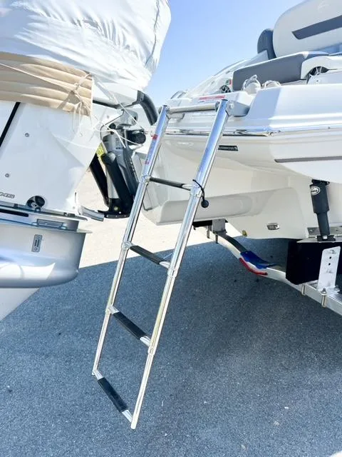 Slide: The Image of 2025 Crownline 290 XSS boat with a metal boarding ladder on a sunny day. - 7
