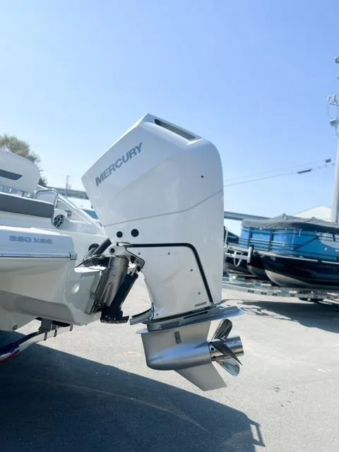 Slide: The Image of 2025 Crownline 290 XSS boat with Mercury outboard motor in a sunny marina. - 9