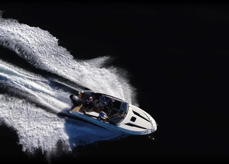 Slide: The Image of 2024 Skamander 850 Voyager speedboat cruising on open water, creating dynamic wake trails. - 20