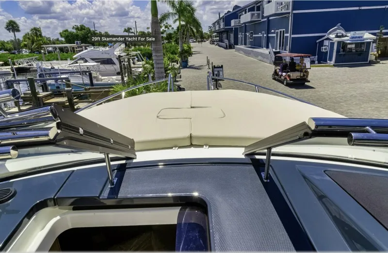 Slide: The Image of 2024 Skamander 850 Voyager yacht at marina, sunny day, palm trees, and blue buildings. - 29