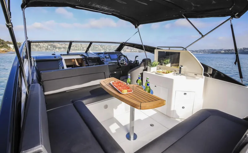 Slide: The Image of 2024 Skamander 850 Voyager luxury boat interior with seating and refreshments. - 6