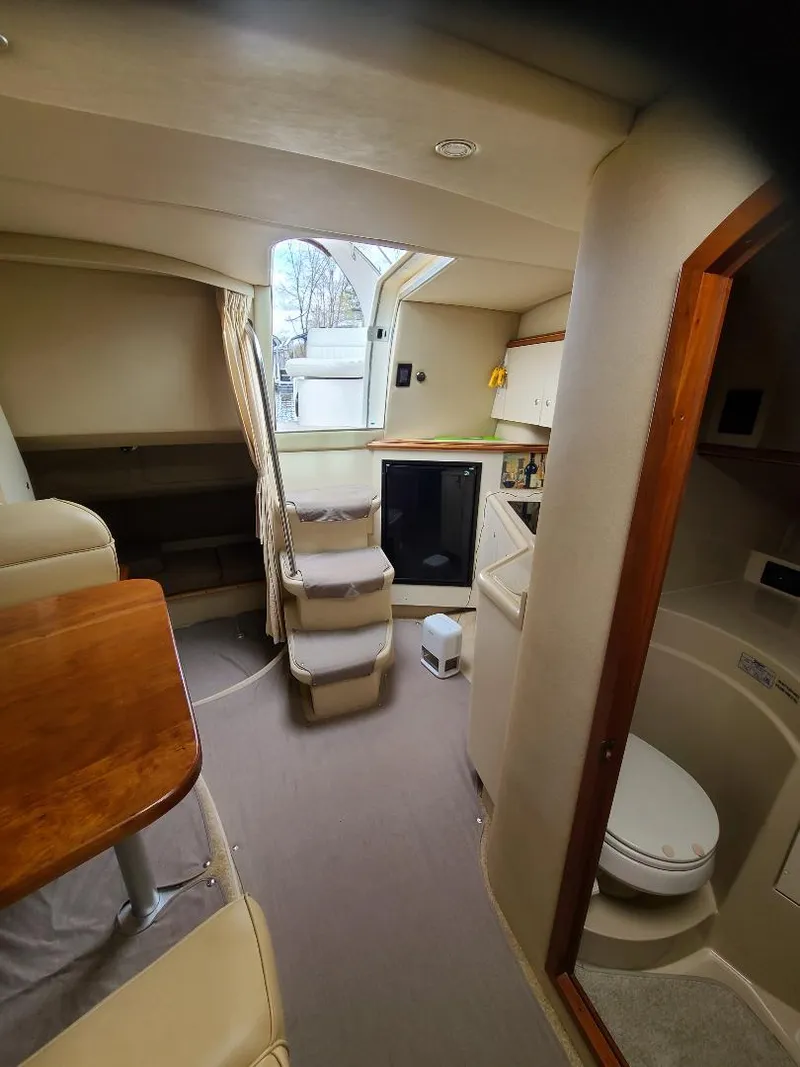 Slide: The Image of Interior of a 2004 Cruisers 3372 yacht, featuring a compact cabin and bathroom. - 13