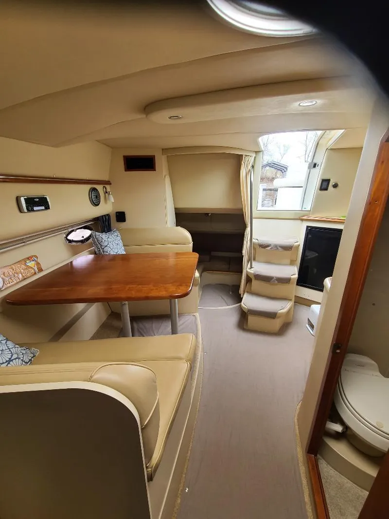 Slide: The Image of 2004 Cruisers 3372 yacht interior with dining area, stairs, and compact bathroom. - 14