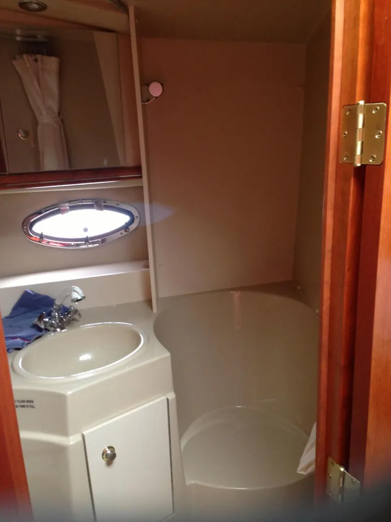 Slide: The Image of 2004 Cruisers 3372 yacht bathroom with sink, mirror, and porthole window. - 2