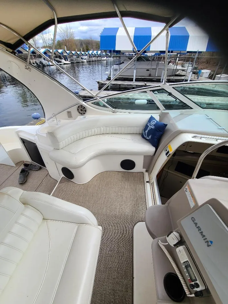 Slide: The Image of 2004 Cruisers 3372 yacht interior with white seating, docked at marina. - 24