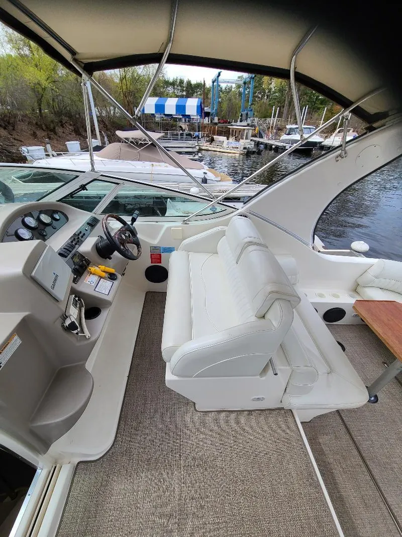 Slide: The Image of 2004 Cruisers 3372 yacht interior with helm, seating, and marina view. - 26