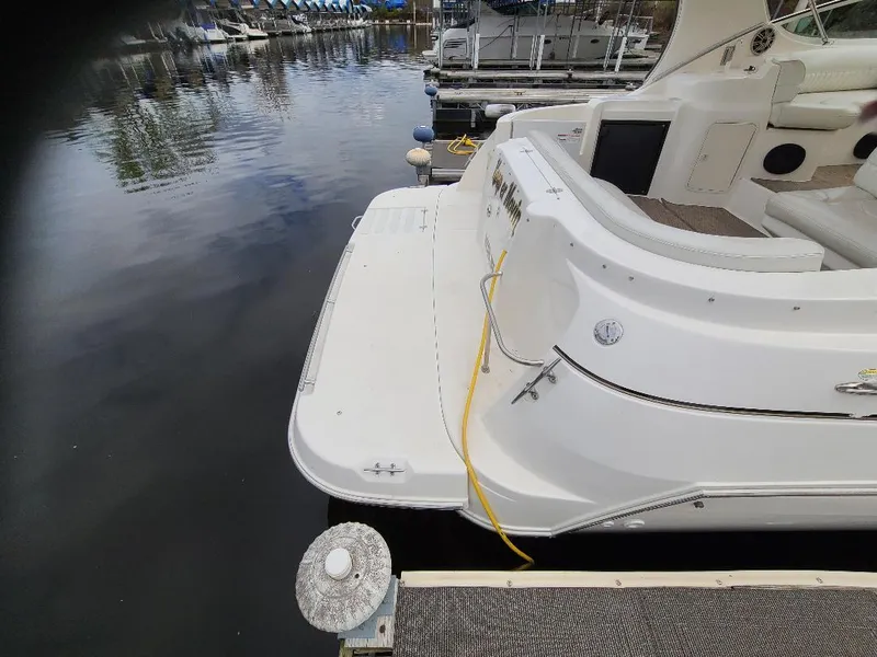 Slide: The Image of 2004 Cruisers 3372 yacht docked at marina, rear view with swim platform and mooring line. - 30