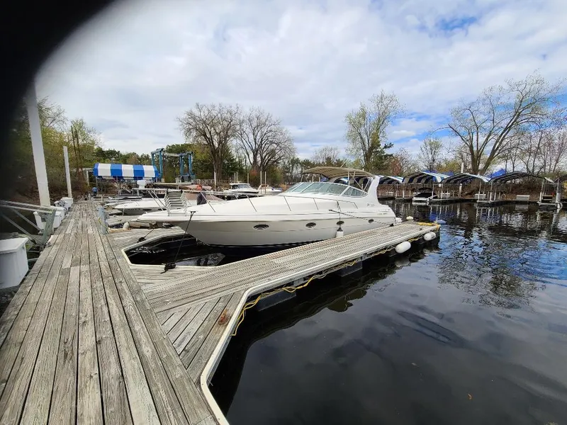 Slide: The Image of 2004 Cruisers 3372 yacht docked at a marina with calm water and cloudy sky. - 9