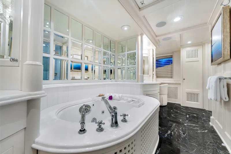 Slide: The Image of Luxurious yacht bathroom with elegant fixtures, marble flooring, and mirrored cabinets in a 1998 Admiral Pilothouse. - 25