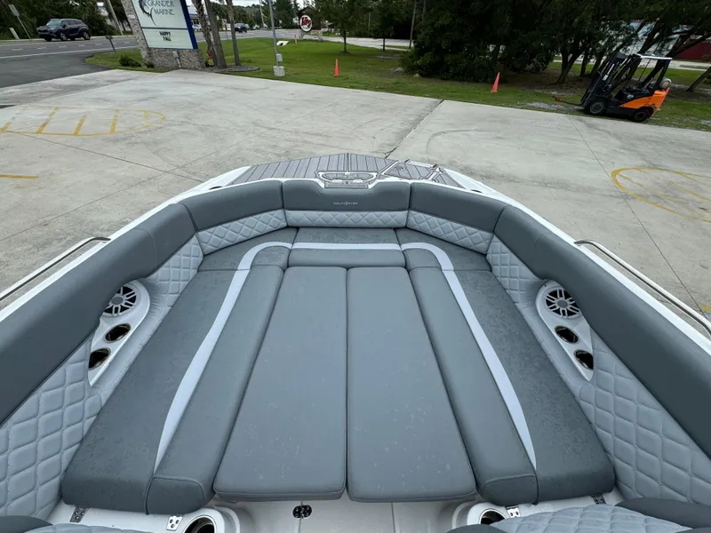 Slide: The Image of 2025 NauticStar 243 DC Deck boat interior with gray cushioned seating and speakers. - 11
