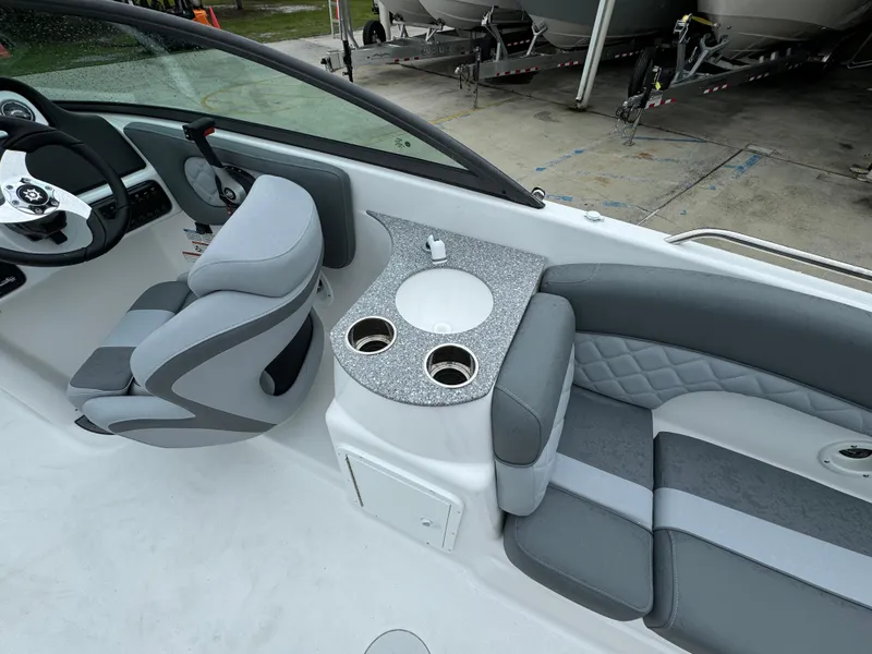 Slide: The Image of 2025 NauticStar 243 DC Deck boat interior with seating and console. - 20