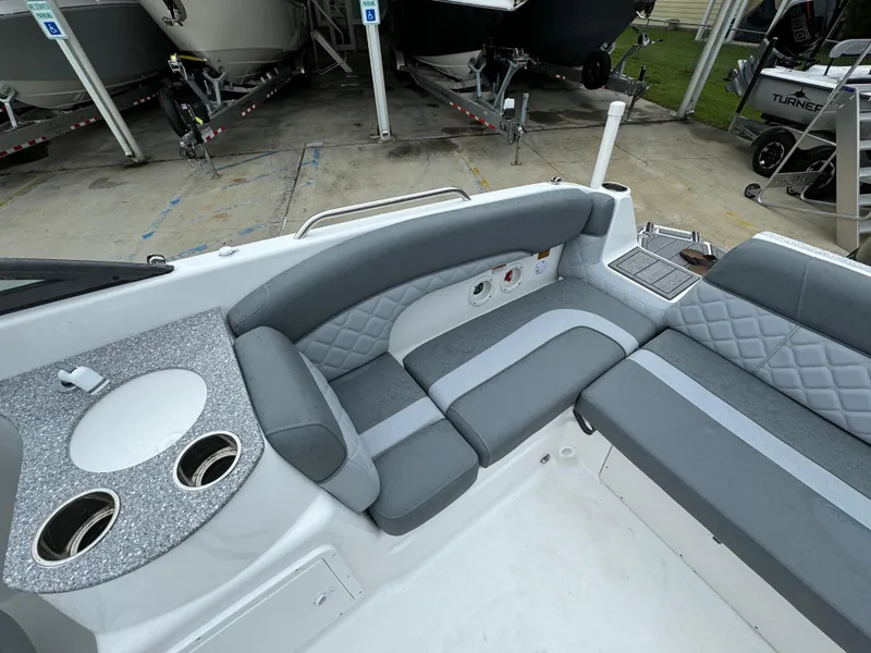 Slide: The Image of 2025 NauticStar 243 DC Deck boat interior with gray seating and cup holders. - 21