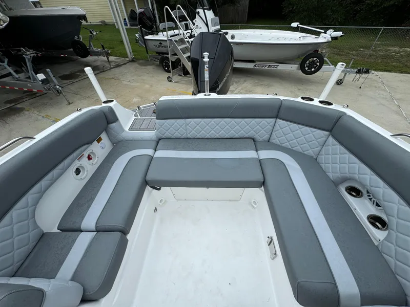 Slide: The Image of 2025 NauticStar 243 DC Deck boat interior with gray seating and cup holders. - 22