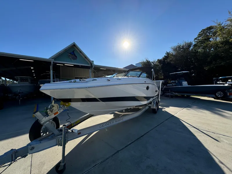 Slide: The Image of 2025 NauticStar 243 DC Deck boat on trailer under sunny sky. - 4
