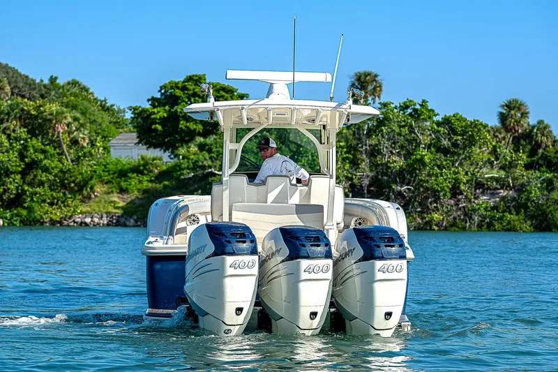 Slide: The Image of 2023 Scout LXF boat with triple 400 engines cruising on a sunny day. - 19
