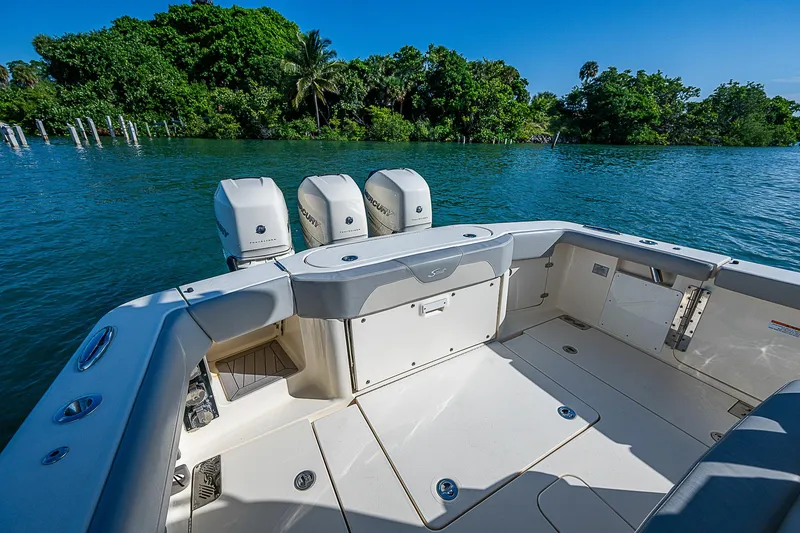Slide: The Image of 2023 Scout LXF boat with triple engines on a serene waterway. - 20