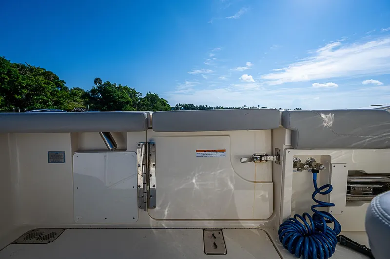 Slide: The Image of 2023 Scout LXF boat deck with blue coiled hose, clear sky background. - 21