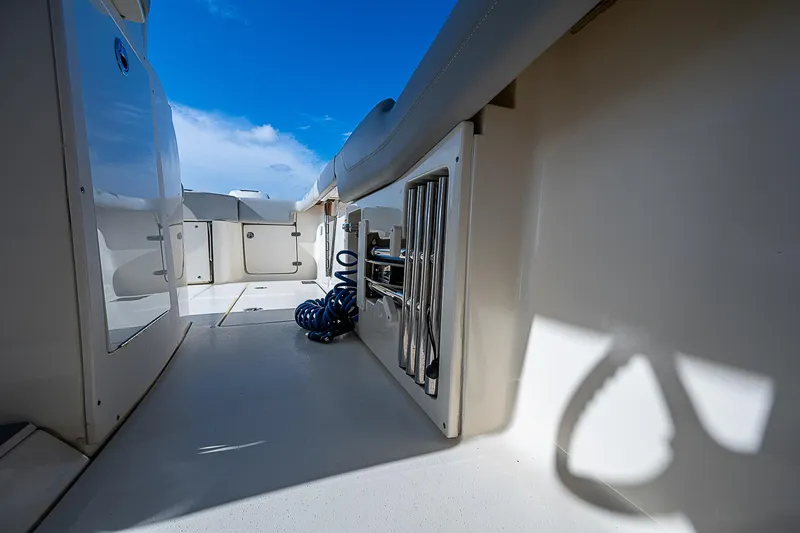 Slide: The Image of 2023 Scout LXF boat interior with storage compartments and coiled hose under a clear blue sky. - 27