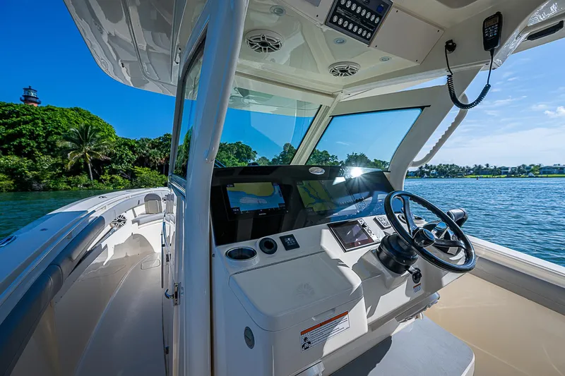 Slide: The Image of 2023 Scout LXF boat interior with steering wheel, dashboard, and scenic water view. - 31