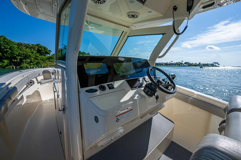 Slide: The Image of 2023 Scout LXF boat interior with steering wheel, dashboard, and ocean view. - 32