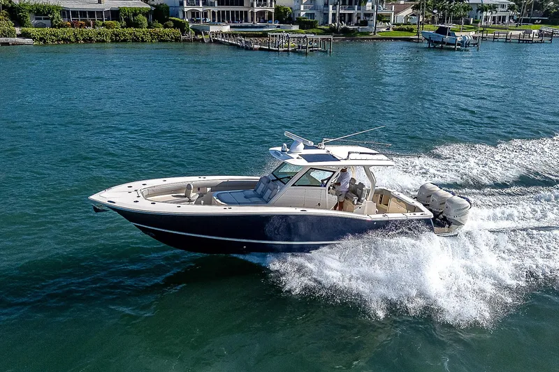 Slide: The Image of 2023 Scout LXF boat cruising on a scenic waterway. - 47