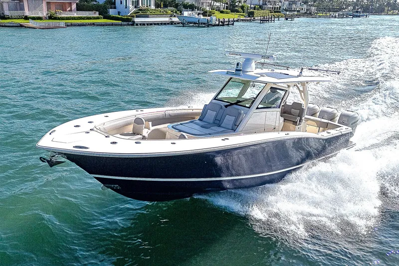 Slide: The Image of 2023 Scout LXF boat cruising on a sunny day in a coastal area. - 48