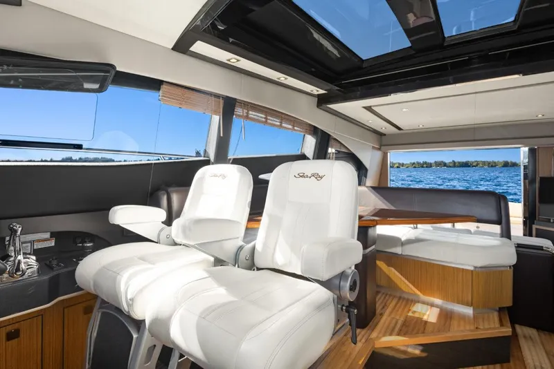 Slide: The Image of Luxurious 2017 Sea Ray L590 Sport yacht interior with white seating and panoramic windows. - 16