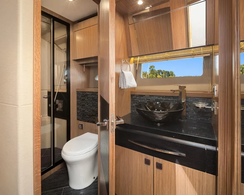 Slide: The Image of Luxurious bathroom in 2017 Sea Ray L590 Sport yacht with modern fixtures and wood accents. - 27