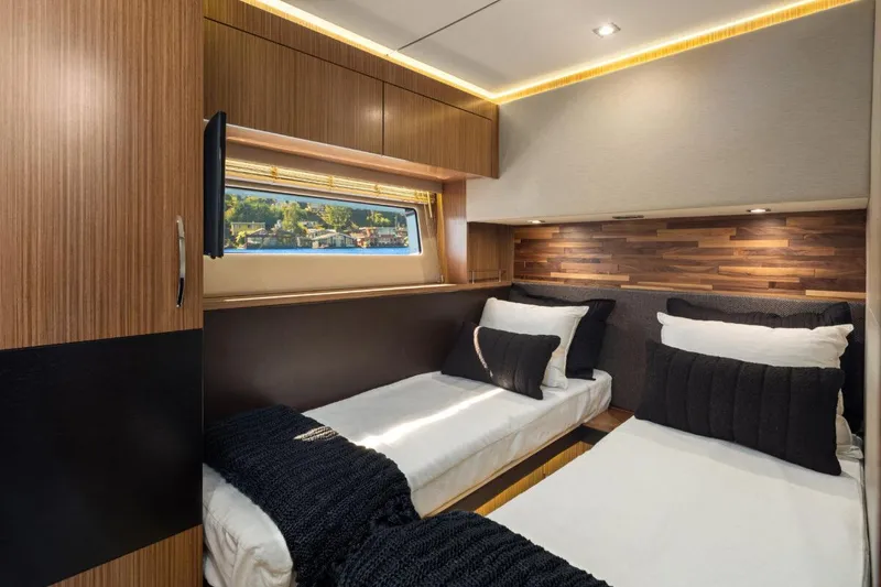 Slide: The Image of Luxurious 2017 Sea Ray L590 Sport yacht cabin with twin beds and modern wood accents. - 30